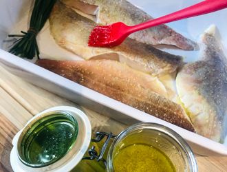 Fisch mit Öl und Gewürzen auf beiden Seiten bepinseln