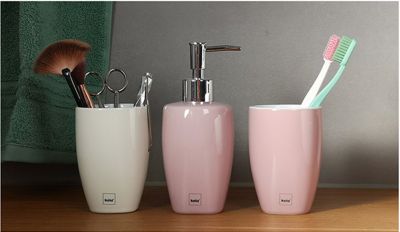 Ceramic soap dispenser and tumbler in pastel colours
