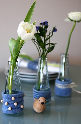 Gläschen auf Tisch mit Blumen arrangiert